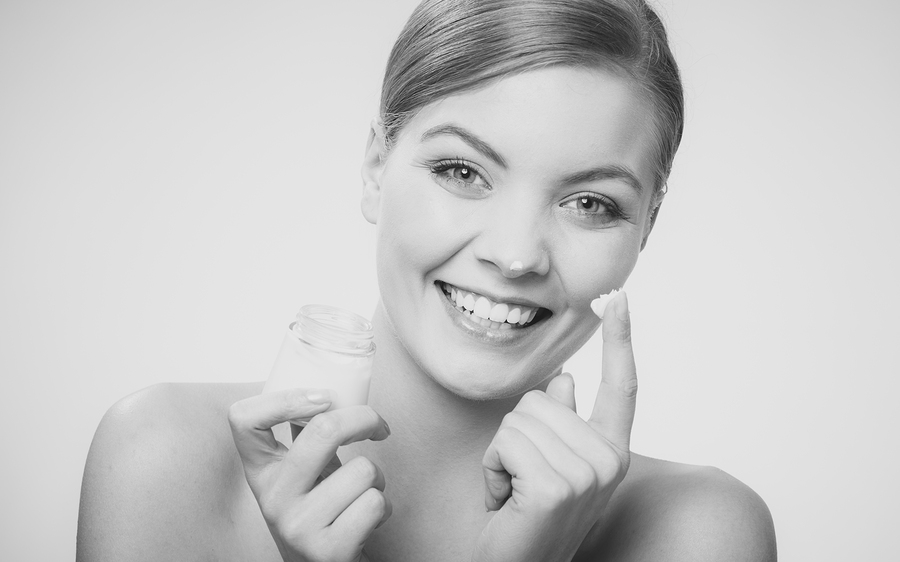 Woman Applying Cream On Her Skin Face.